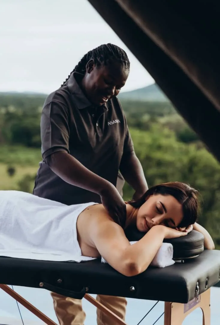 Woman receiving a massage at an outdoor spa overlooking the Serengeti bush, Tanzania