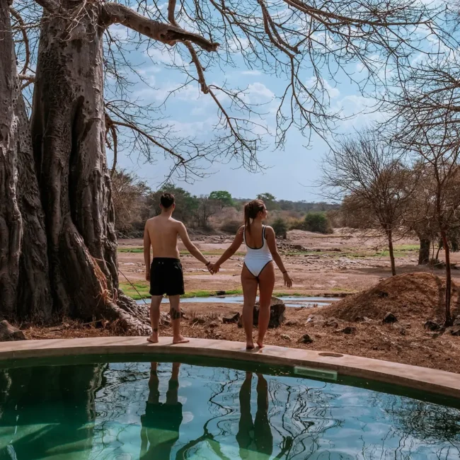 Couple enjoying a private plunge pool at a luxury safari lodge in Tanzania surrounded by iconic baobab trees.