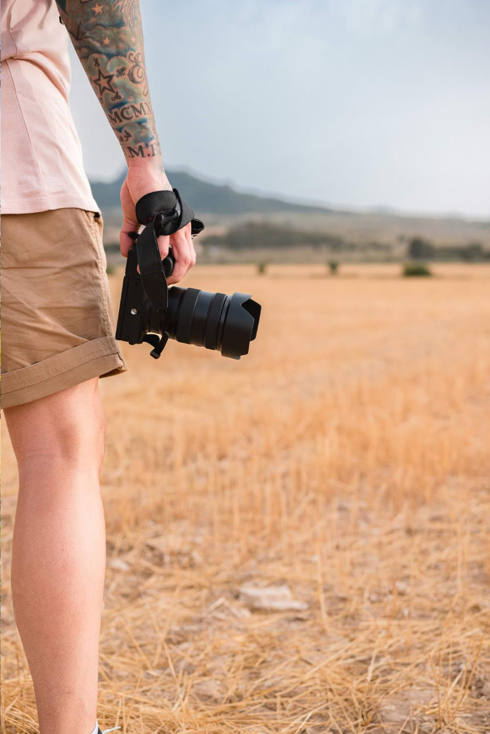 Photographer holding a camera overlooking open grassland on a Tanzania safari